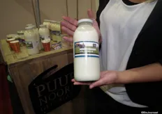 Pleunie toont melk van de Harmanna Hoeve, de boiologisch-dynamische melkveehouderij van Anne en Anneke Koekkoek.